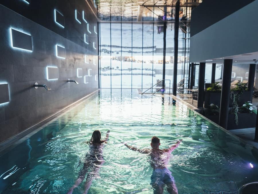 Una piscina techada, sillones reclinables de piscina