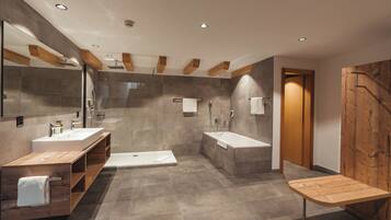 Un baño moderno con un lavamanos grande, bañera y ducha.