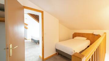 Ein Schlafzimmer mit einem Bett, einem hölzernen Kopfteil und einem Nachttisch.