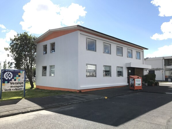A white building with multiple windows and a signboard.