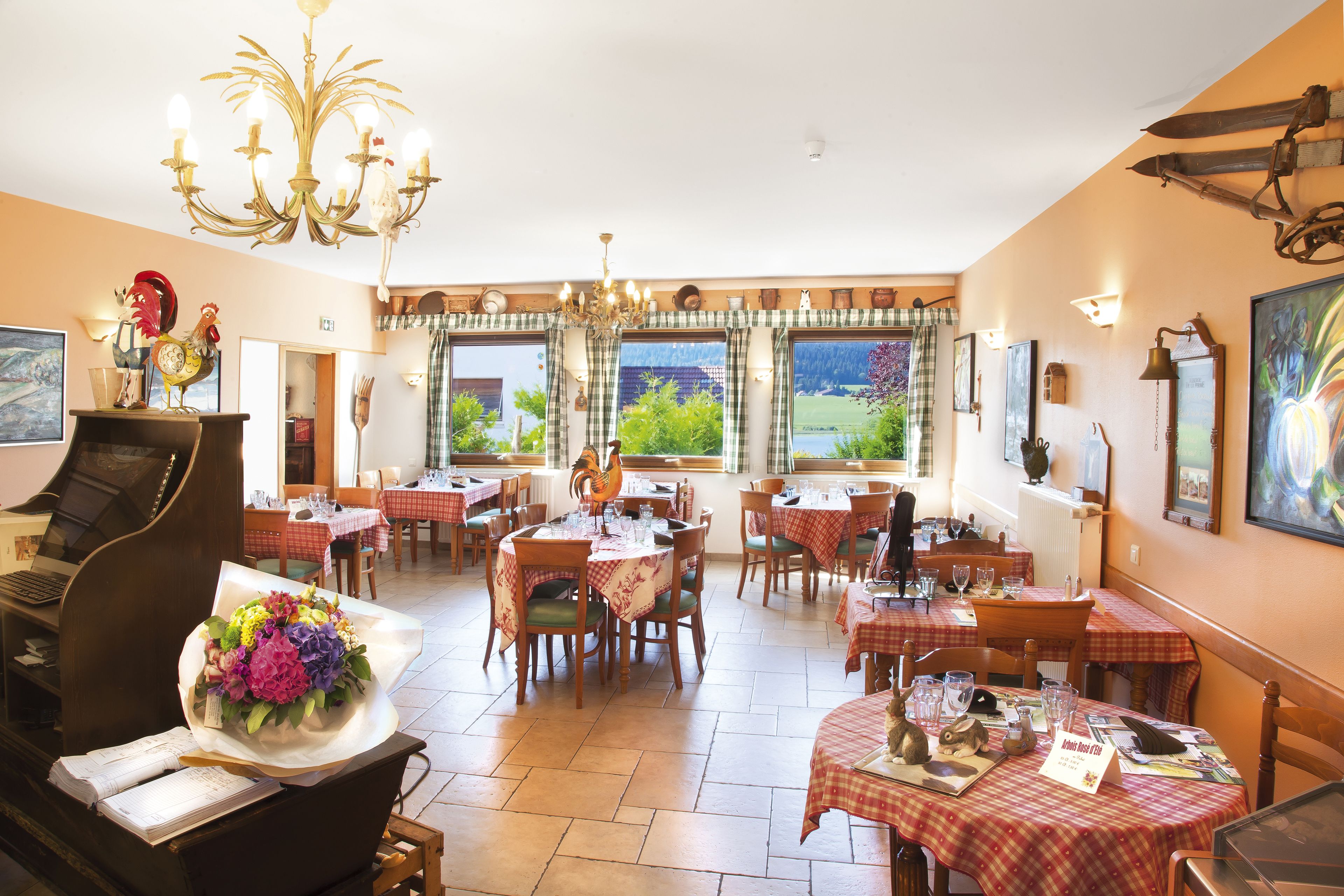 Un comedor con varias mesas, sillas y un piano.