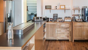 Una cocina moderna con armarios de madera, un refrigerador de acero inoxidable y una encimera amplia.