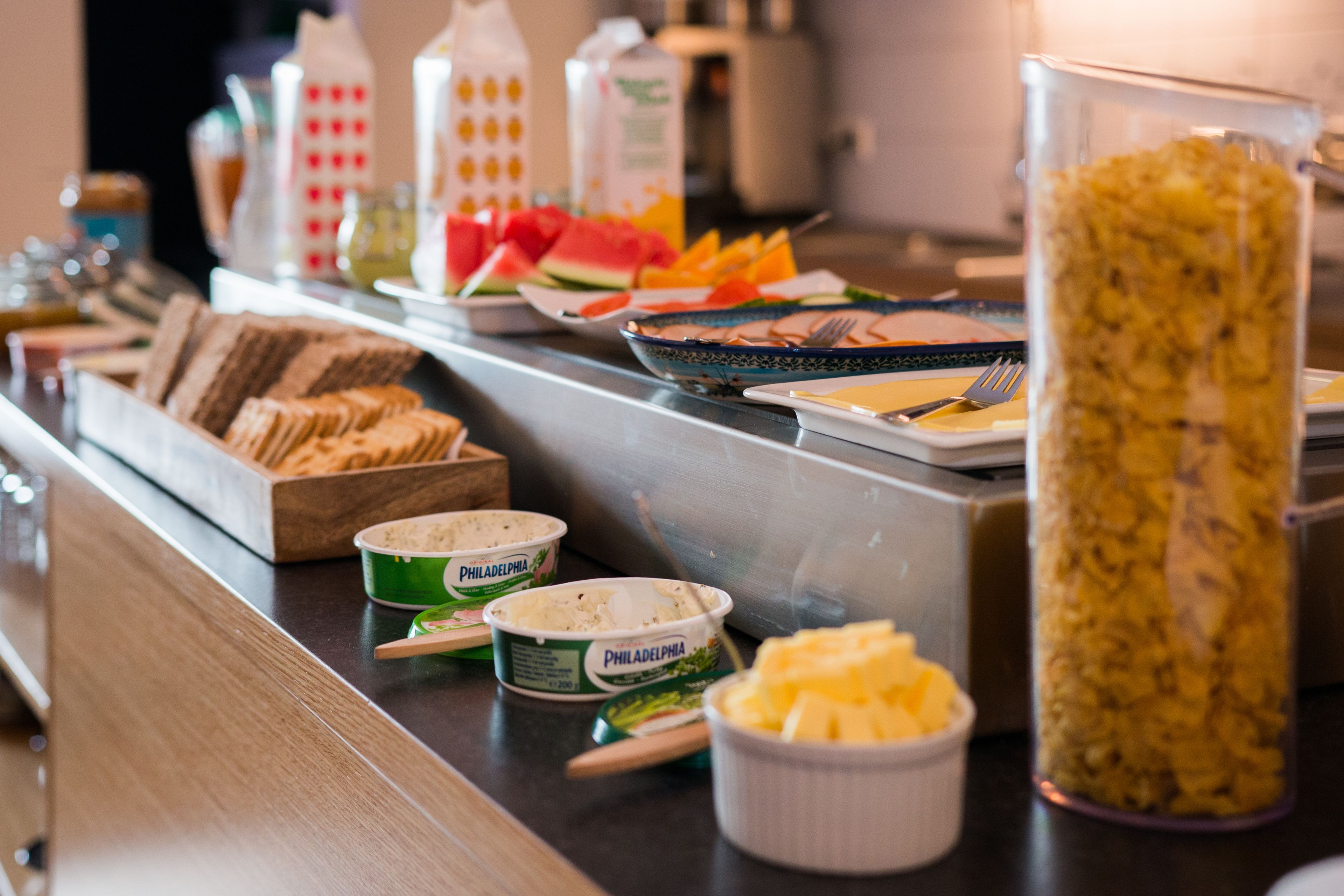 A buffet with various food items including bread, fruits, and dips.