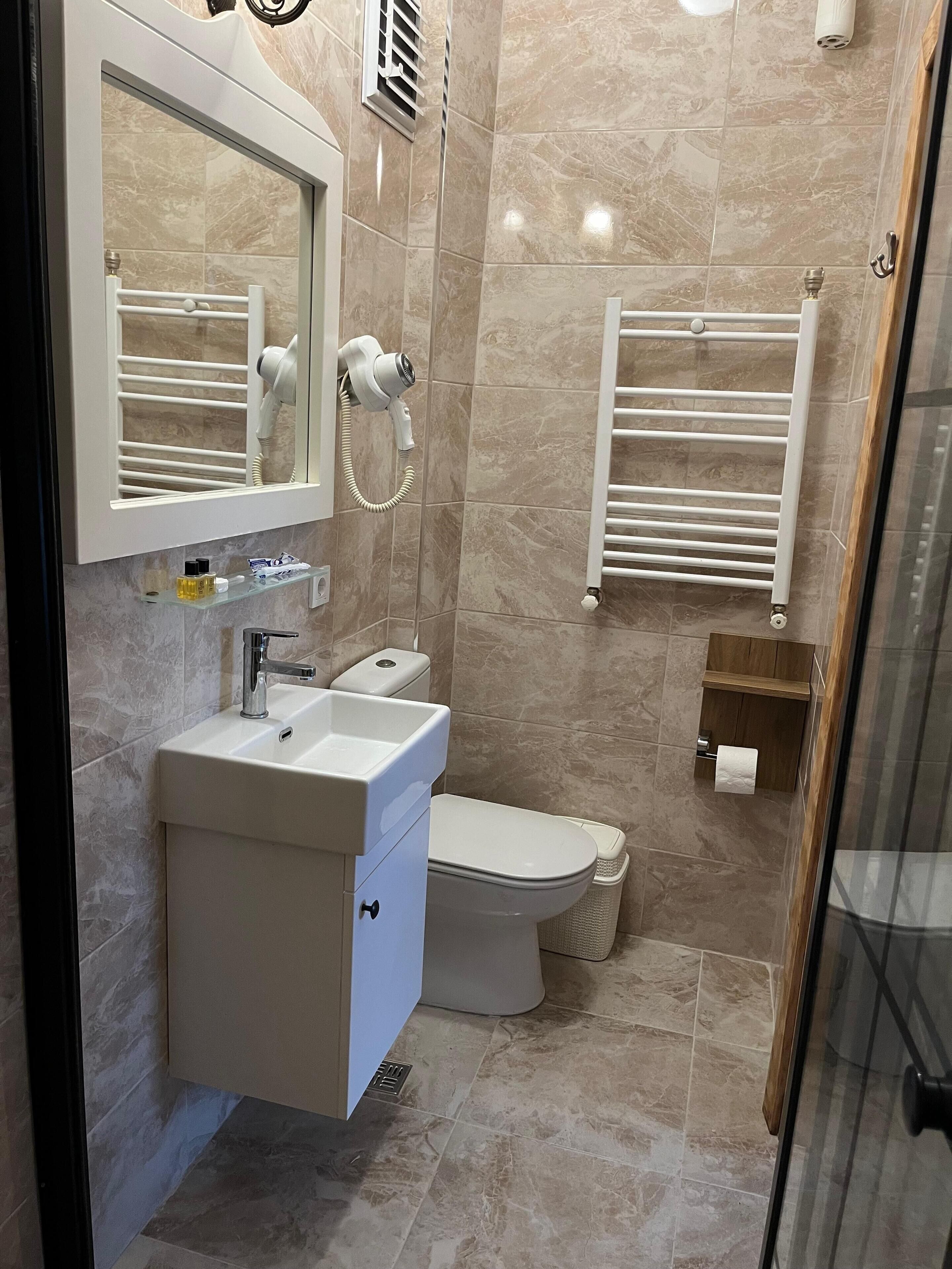 A modern bathroom with a sink, toilet, and towel rack.