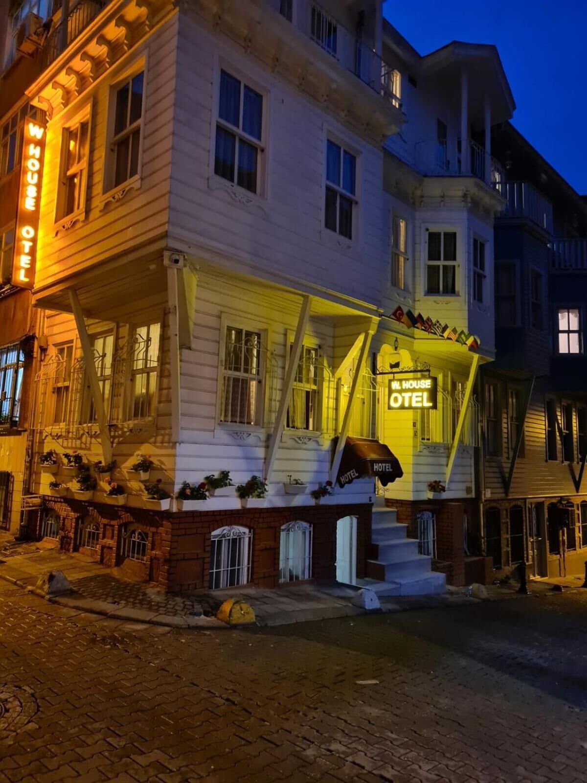 A two-story building with a prominent 'WHOUSE HOTEL' sign.