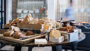 A buffet with various breads, pastries, and desserts. - 65 Hotel, Rothschild Tel Aviv - an Atlas Boutique Hotel (Tel Aviv)