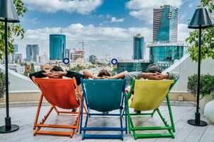 Four colorful chairs facing a city skyline with modern buildings.