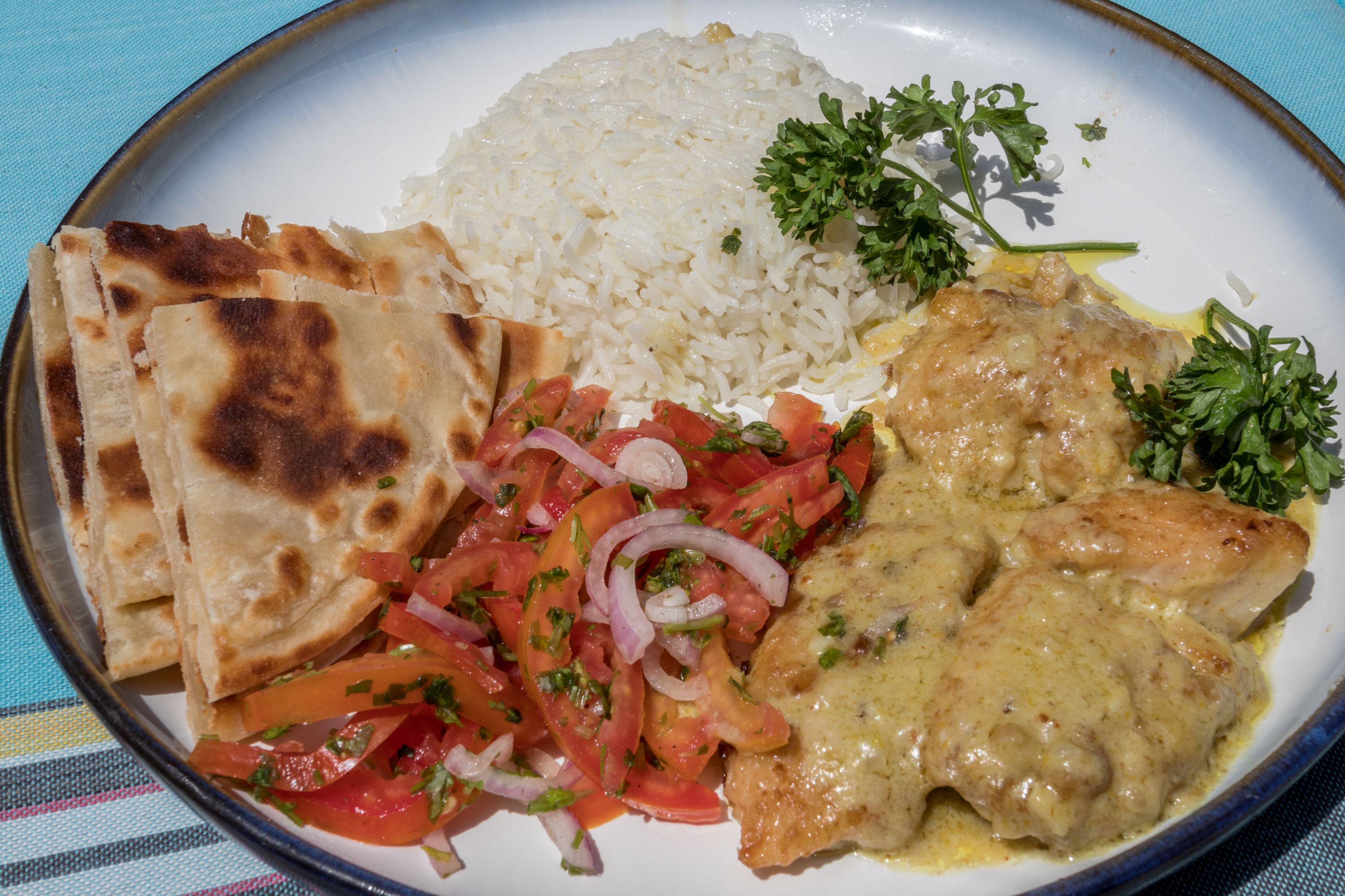 A plate of food including rice, chicken, and vegetables.