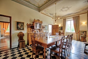 Comedor con piso a cuadros, muebles de madera y una araña.