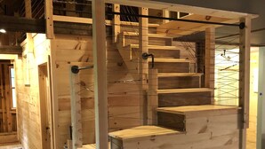 Una escalera de madera con barandilla y escalones de madera clara.