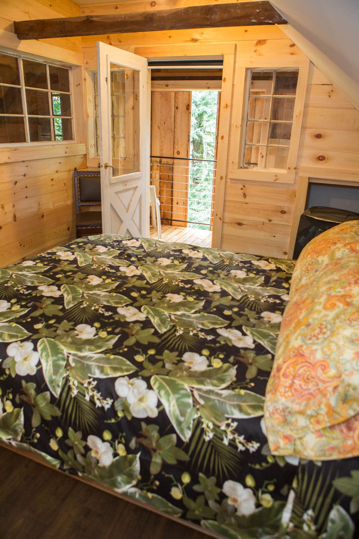 Dormitorio de cabaña de madera con cama, una silla y una chimenea.