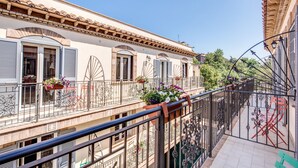 Un immeuble à plusieurs étages doté de balcons, de garde-corps en fer forgé et de jardinières.