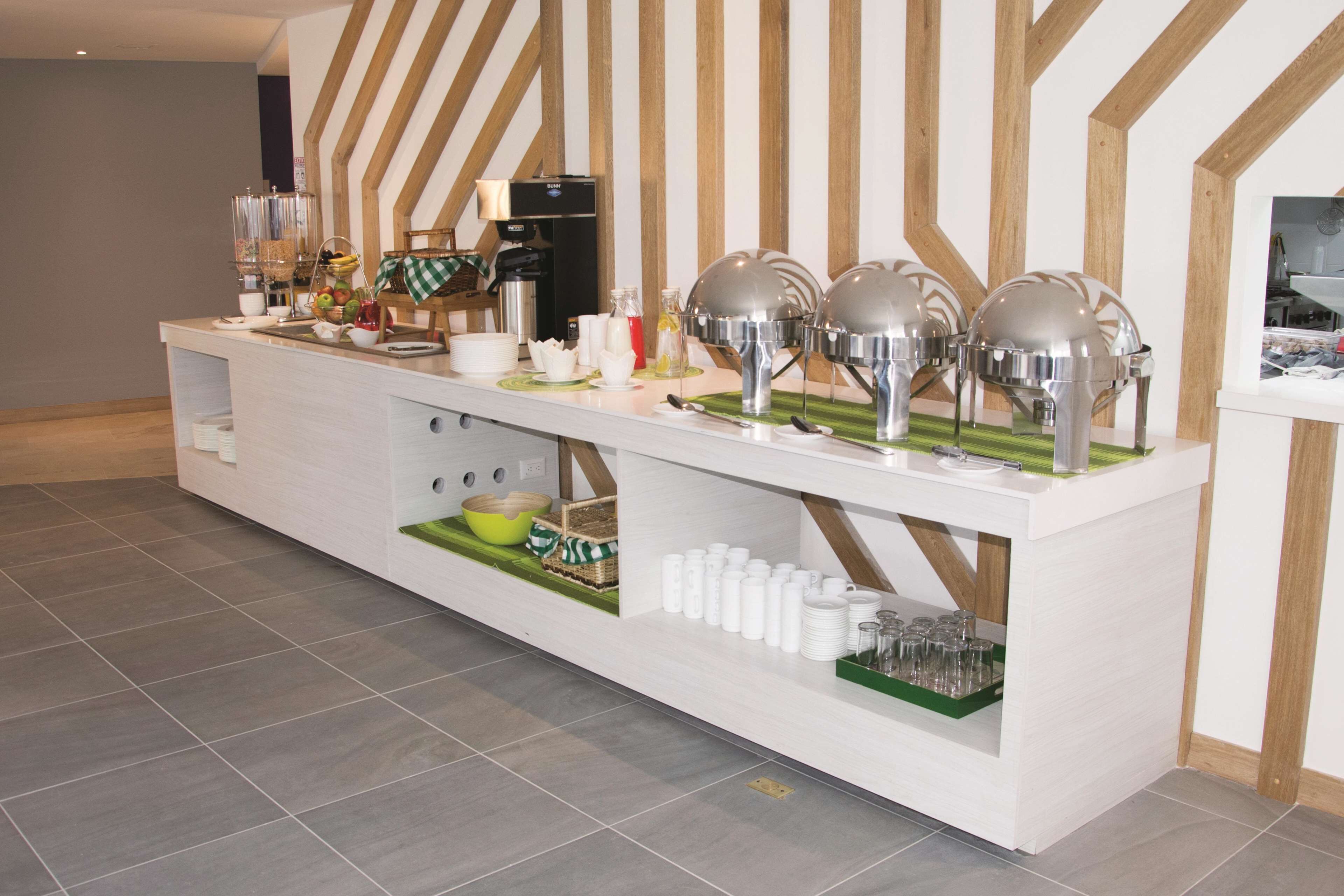 Montaje de bufé con diferentes alimentos y utensilios para servir.