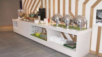 Montaje de bufé con diferentes alimentos y utensilios para servir.