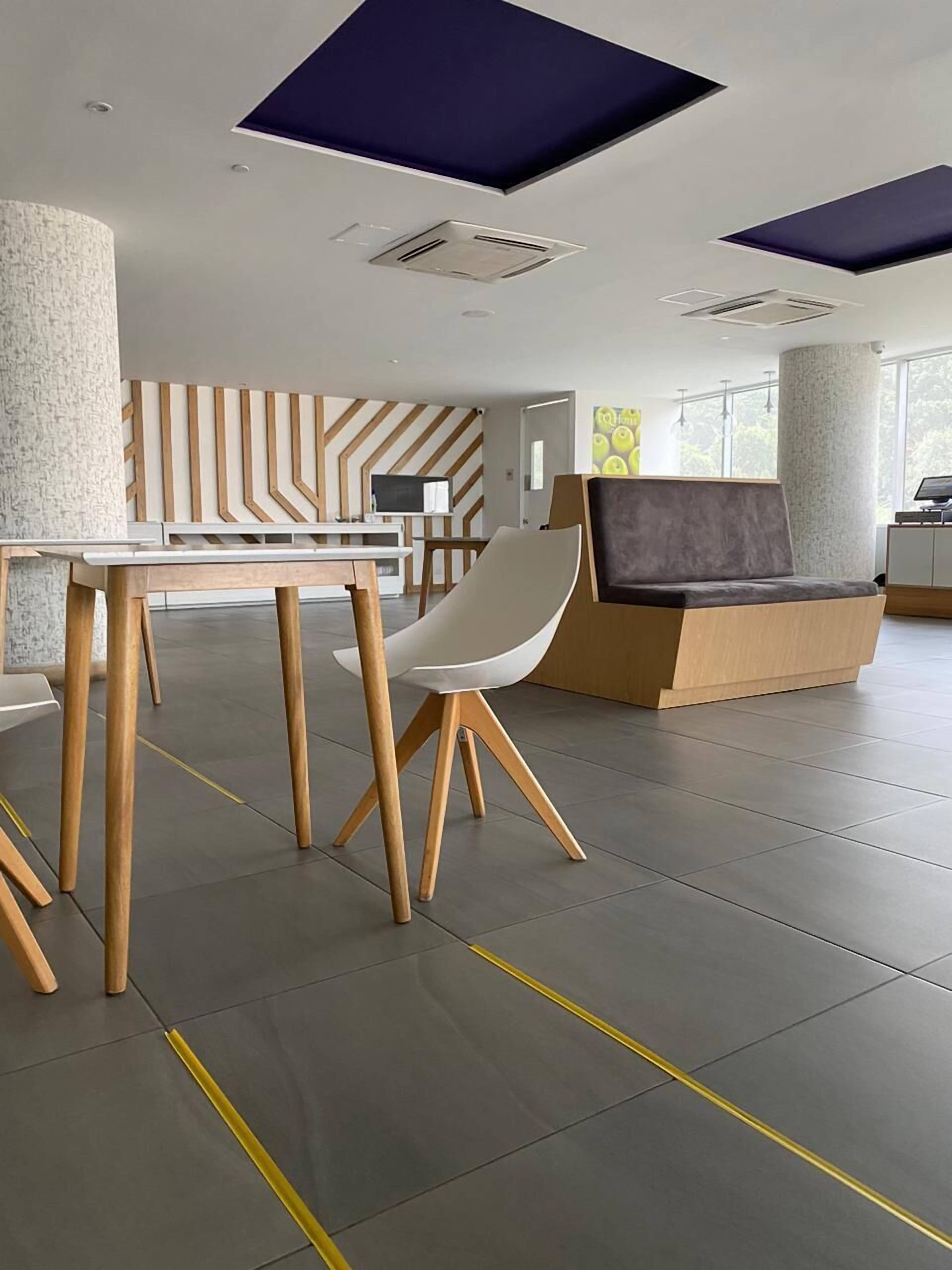 A modern interior with a reception desk, seating area, and a large window providing natural light.