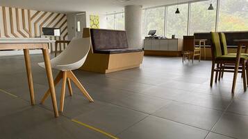 A modern interior with a reception desk, seating area, and large windows.