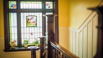 A staircase with a stained glass window featuring a landscape scene.