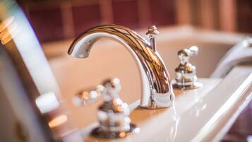 A bathroom with a chrome faucet and a mirror.