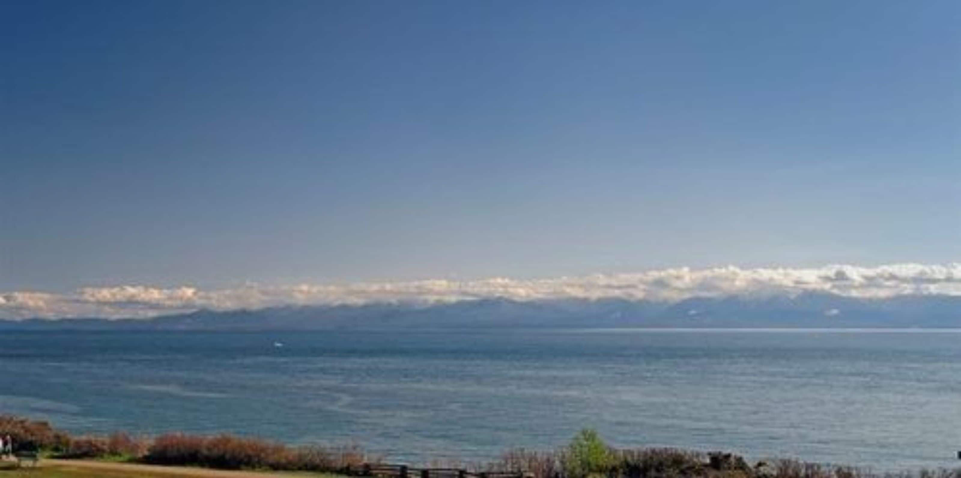 Un paisaje costero con vista al mar y montañas a lo lejos.