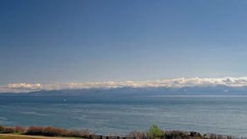 Un paisaje costero con vista al mar y montañas a lo lejos.