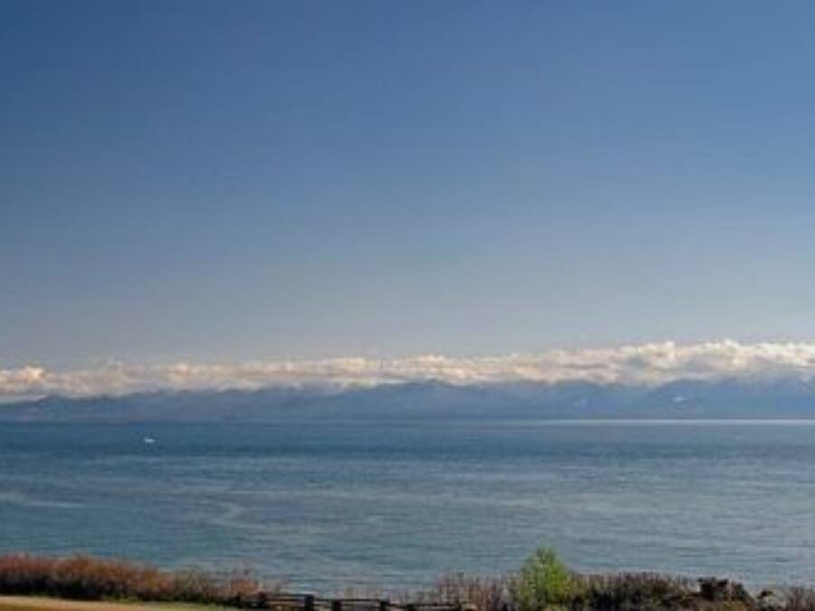 Un paisaje costero con vista al mar y montañas a lo lejos.