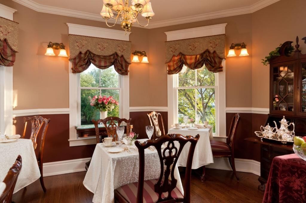 A dining room with two tables set for a meal, surrounded by chairs.