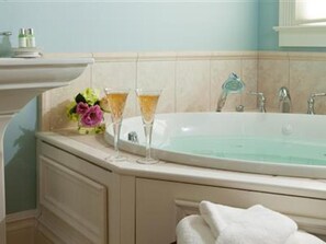 A bathroom with a bathtub, a sink, and a window.