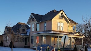 Una casa de dos pisos con un porche y un letrero que dice 'Houston House'.