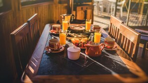A breakfast table with orange juice, coffee cups, and a fruit plate. - Pichilemu Domos (Pichilemu)