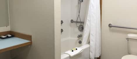Un baño con bañera, inodoro y lavamanos con toallero.