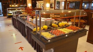 A buffet area with various food items and a glass display case. - Raupp Flats Gramado 01 (Gramado)