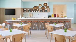 Una cocina moderna con una isla central, armarios de madera y un televisor de pantalla plana.