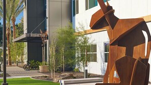 Un edificio moderno con una escultura original en su fachada.