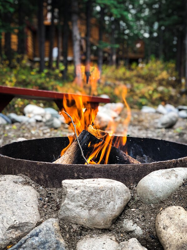 A campfire with logs and rocks around it.