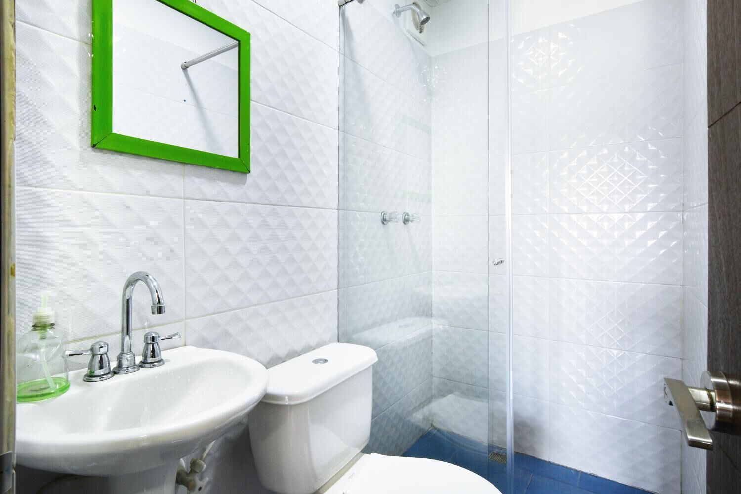 A bathroom with a sink, toilet, and shower.