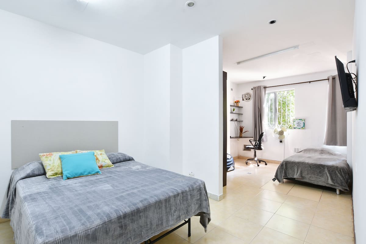 Un dormitorio con una cama, un escritorio y una silla.