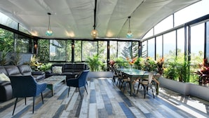 A spacious indoor area with a large table and chairs, a sofa, and a coffee table.