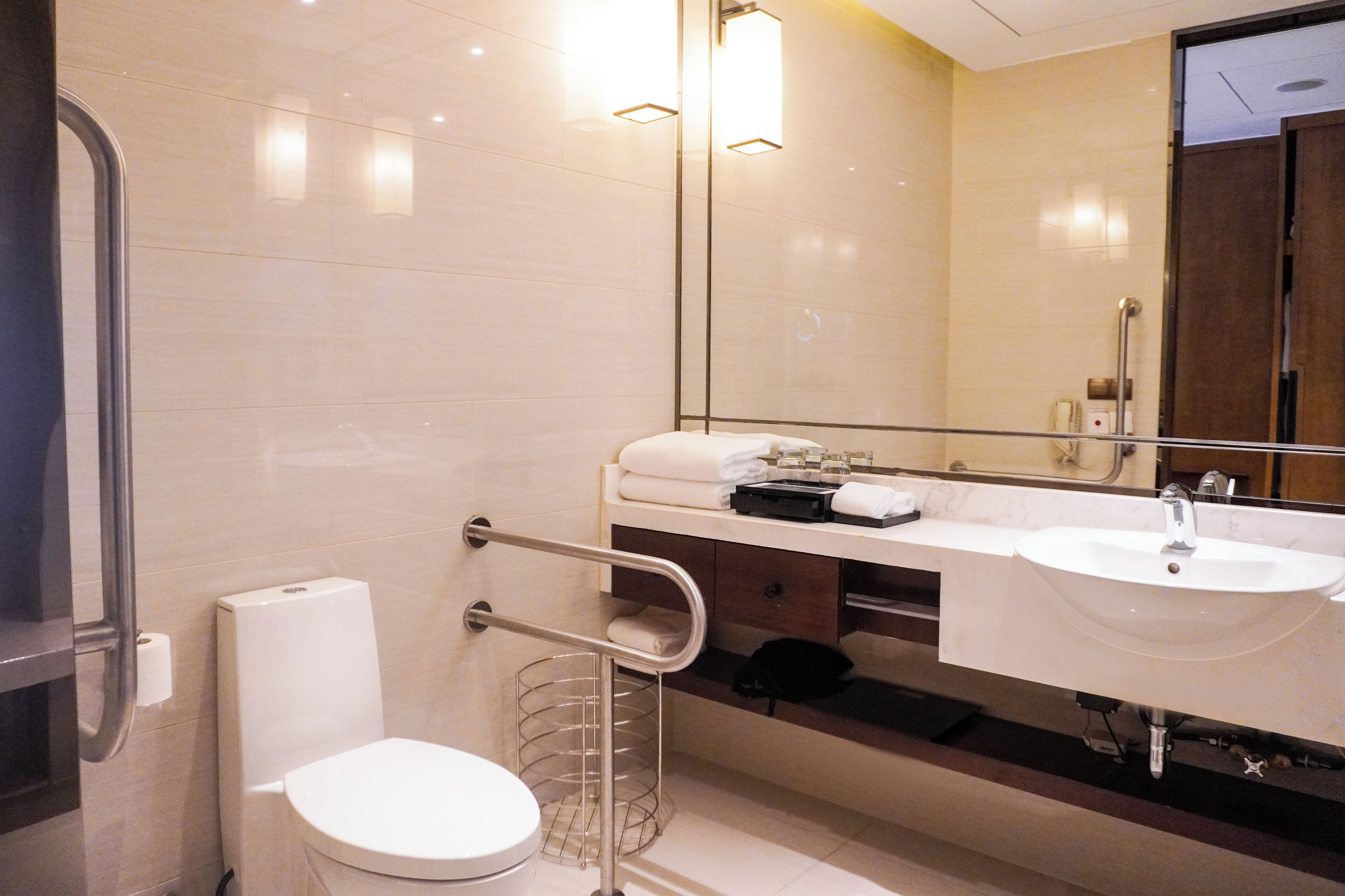 Une salle de bain moderne avec des toilettes blanches, un lavabo et un miroir.