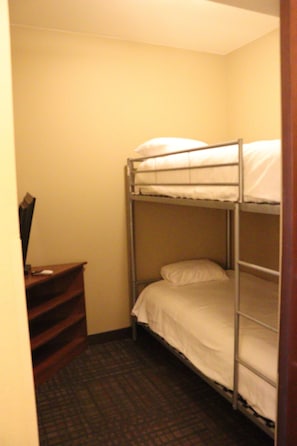 Cozy retreat with a bunk bed, desk, and comfortable seating area.