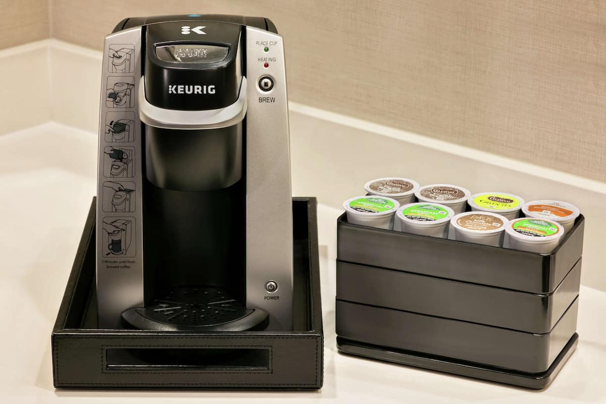 A Keurig coffee maker with a coffee pod holder beside it.