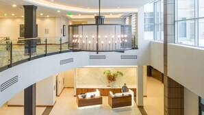 A spacious lobby with a reception desk, seating area, and a balcony. - Embassy Suites by Hilton Berkeley Heights (Berkeley Heights)