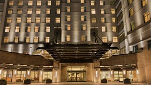 A modern hotel entrance with a central glass door, multiple floors, and a covered entrance area. - Embassy Suites by Hilton Berkeley Heights (Berkeley Heights)