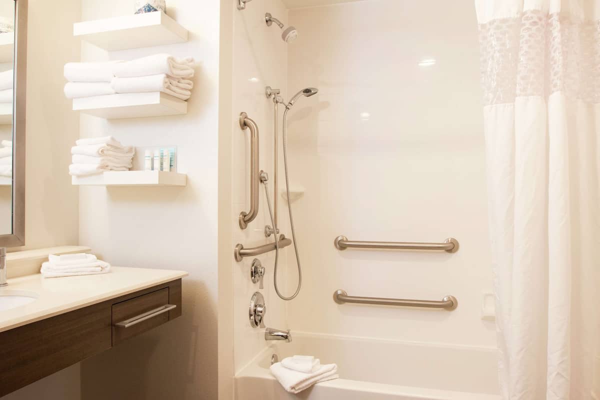 A modern bathroom with a bathtub, shower, and vanity.
