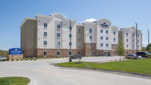 Ein mehrstöckiges Hotel mit modernem Design, das ein gut sichtbares Schild für Candlewood Suites zeigt.
