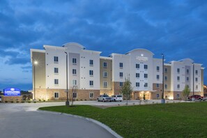 Een hotel met meerdere verdiepingen, in modern design, met een opvallende ingang en een parkeerplaats.