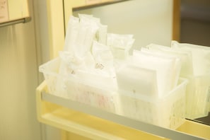 Een opbergruimte met plastic bakken gevuld met diverse spullen.