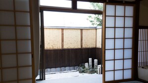 A traditional Japanese room with tatami flooring, a shoji screen door, and a view of a snow-covered garden. - Kyo no Yado Jorinji (Kyoto)