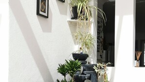 A garden with various plants, a deer statue, and a small waterfall feature. - Lush & Co Auckland Bed & Breakfast (Auckland)