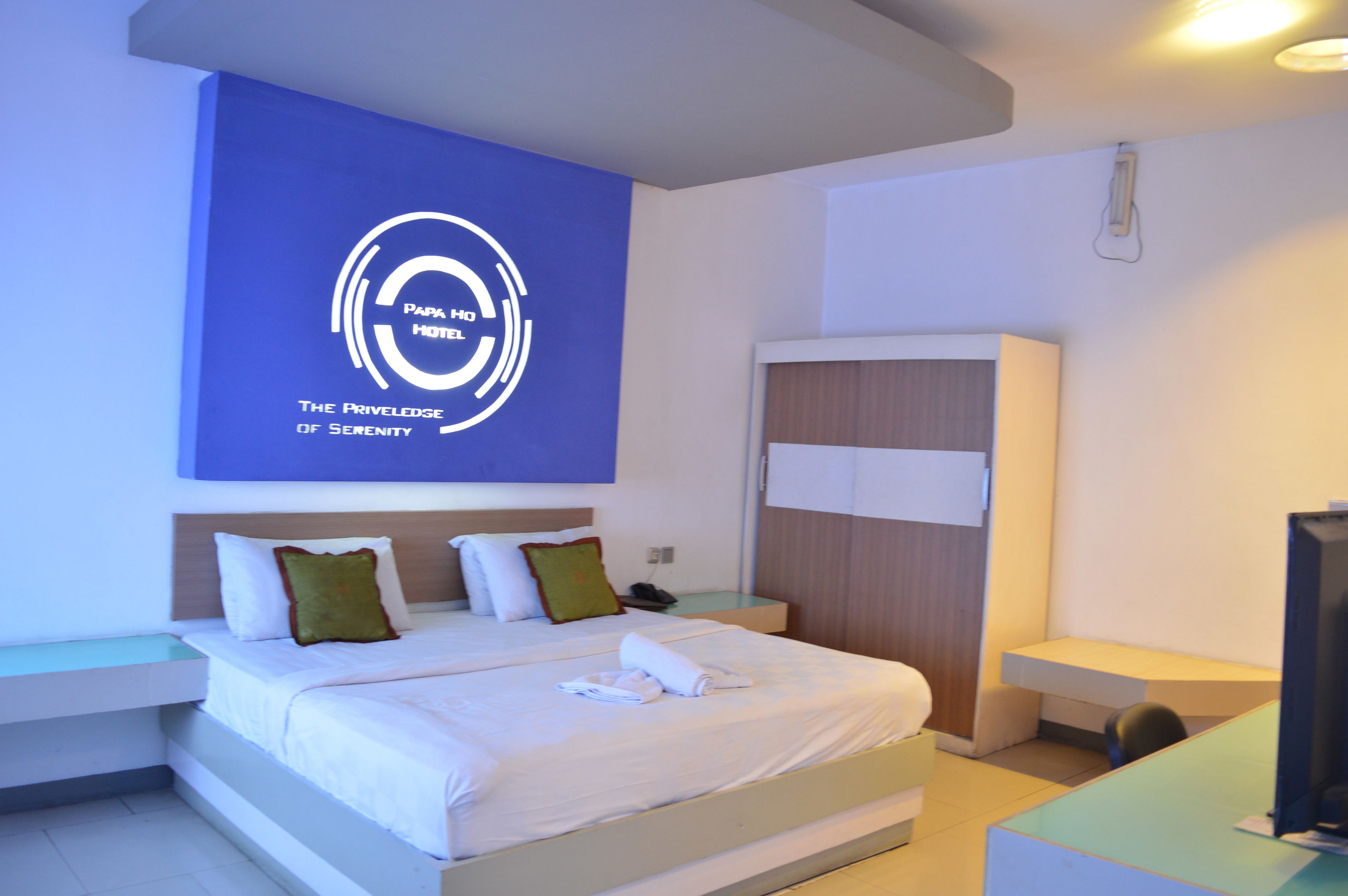 A modern hotel room with a large bed, a desk, and a TV.