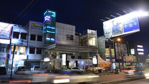 Un edificio de varios pisos con diversas tiendas y un cartel llamativo.